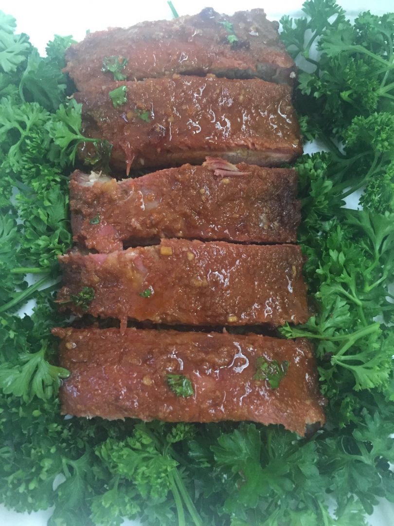Presentation of ribs - five neat slices on a bed of herbs. Photo: Supplied