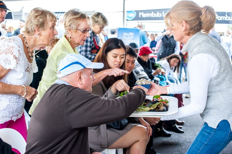 Samples are handed to the crowd during a cooking demonstration at 2018's Narooma Oyster festival. Picture: provided. 