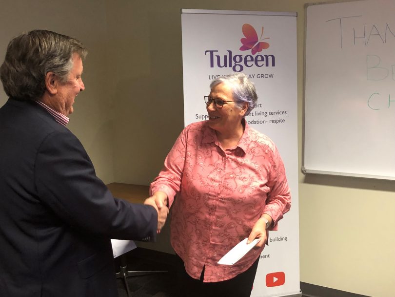 Acting Bega Cheese Chairman Max Roberts presents the donation to Tulgeen CEO Jen Russell. Photo: Supplied. 