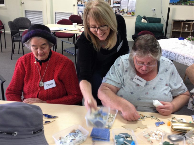 Gypsy Soul Studio's Kay Bowerman helps senior citizens at the regular Meals On Wheels Wednesday social group create a mosaic. Photo: Elka Wood.