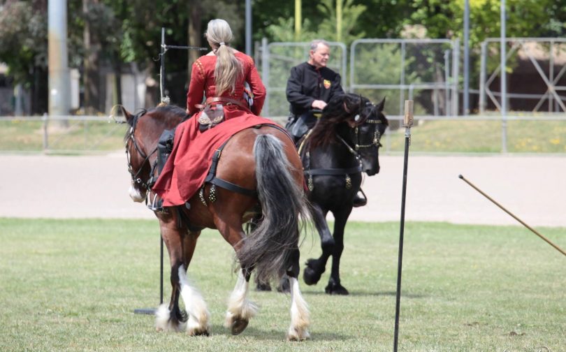 Lady and man on horses wearing medieval clothing
