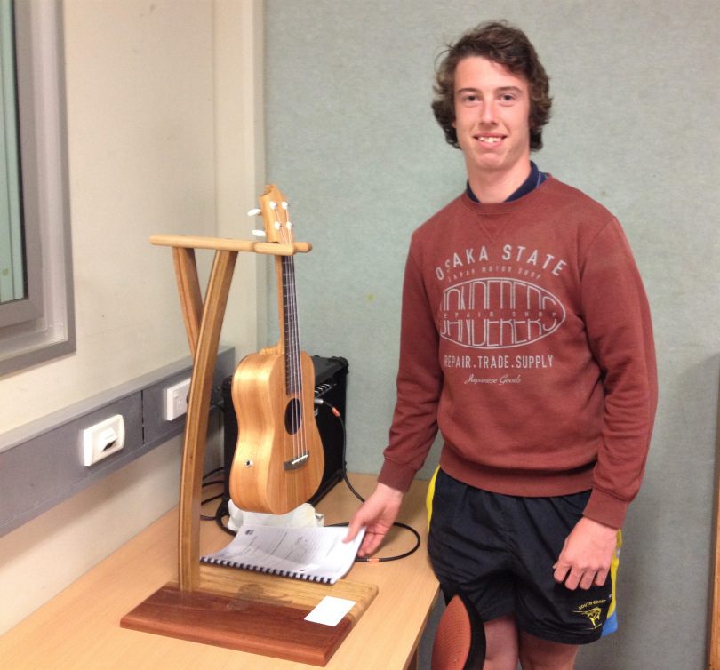 Zac Harlow with the ukulele stand he made for his HSC project. Zac says he dosen't even play the Uke but thought it would be a good project. Photo: Elka Wood. 