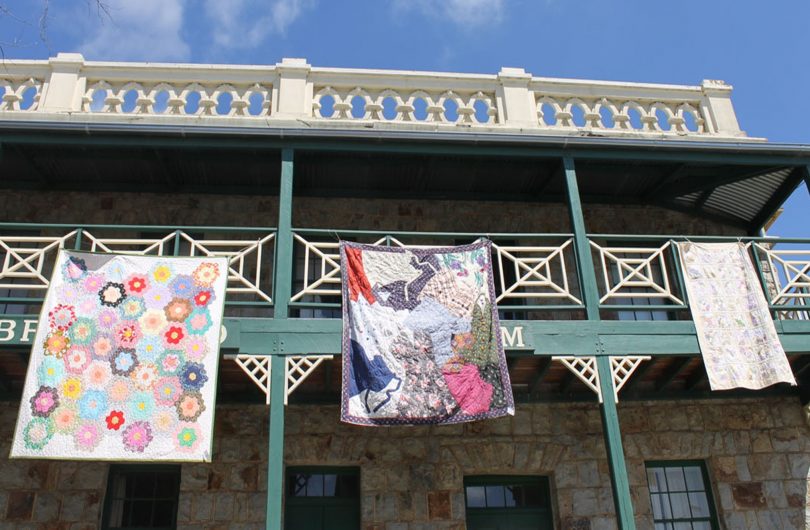 Quilts hang from the Braidwood Museum