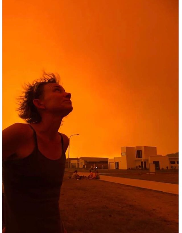 Tomakin resident looking up at orange sky during bushfire.