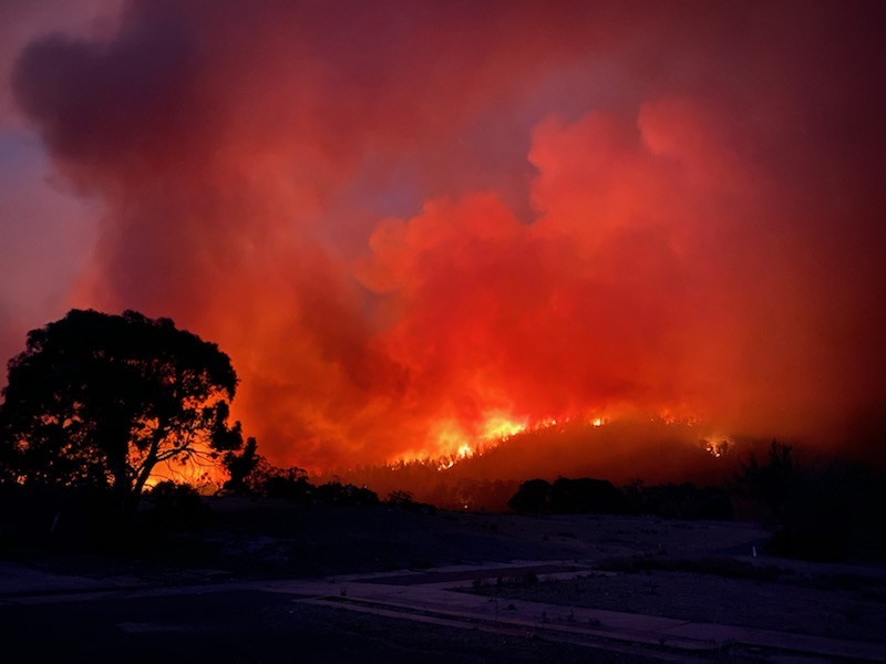 Bushfire burning in distance at night.