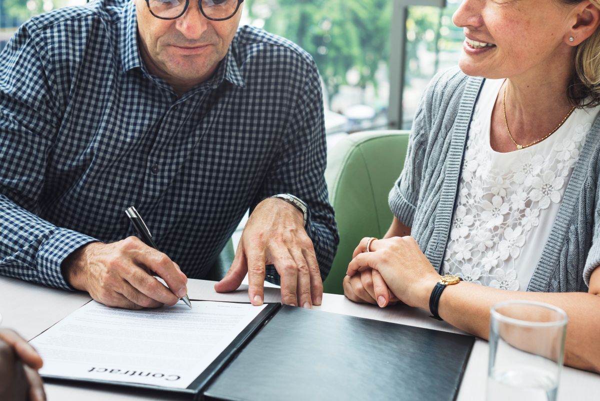 two people signing a document