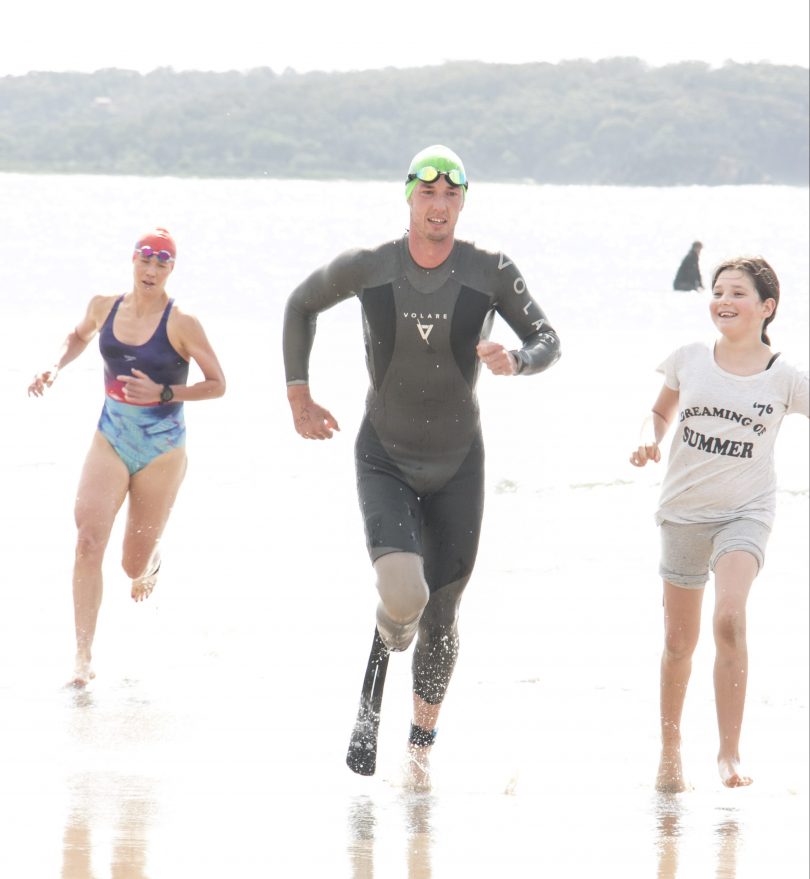 Clint Picken from Canberra, second in the over thirties, beamed as his step daughter Decoda met him in the shallows with a prosthetic leg to help with the run to the finish line. Photo: Supplied.