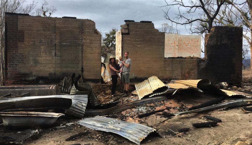 Felicie Vahcon and family stand among ruins of burnt family home in Yowrie.