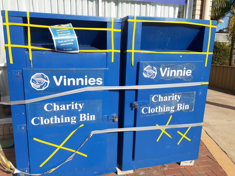 Two Vinnies charity bins with tape across the front to stop donated items going in them.