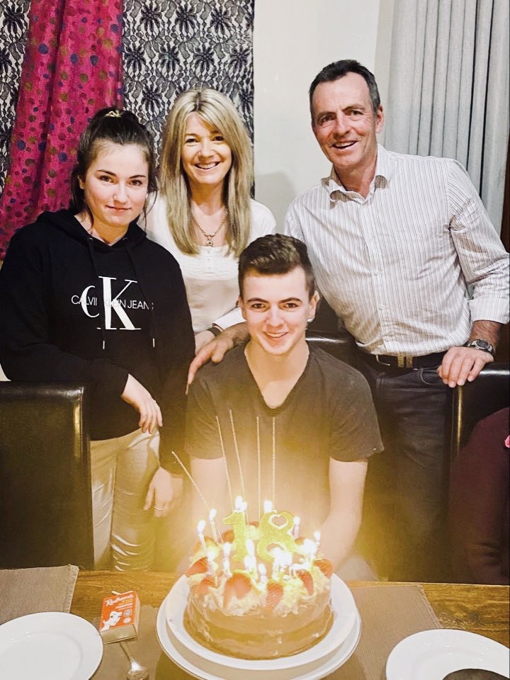 HArry Cleverdon posing with his family and a cake to celebrate his 18th birthday.