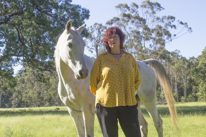 Jo Dodds standing in a field with her horse.