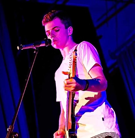 Harry Cleverdon performing with guitar onstage.