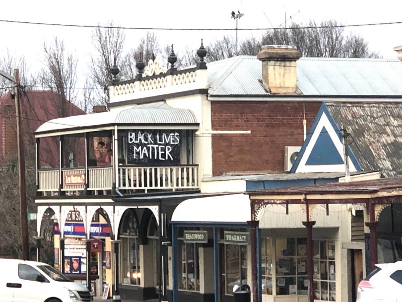 "Black Lives Matter" banner hanging from balcony of Braidwood building.