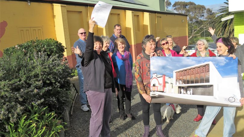 Narooma School of Arts team celebrating approval of the council development application, holding picture of proposed new building.