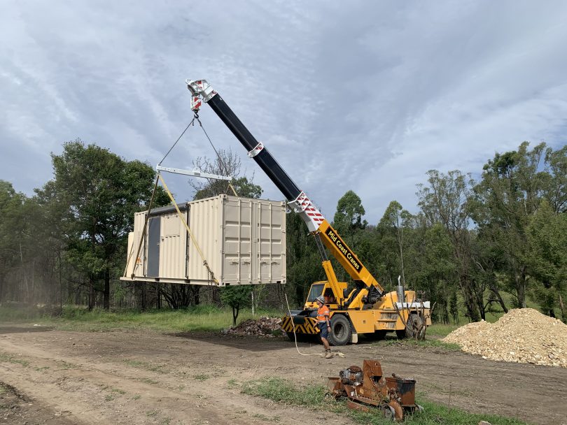 Crane lifting temporary accommodation pod.