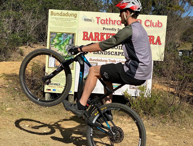 Michael Parker riding his bike in bushland in Tathra.