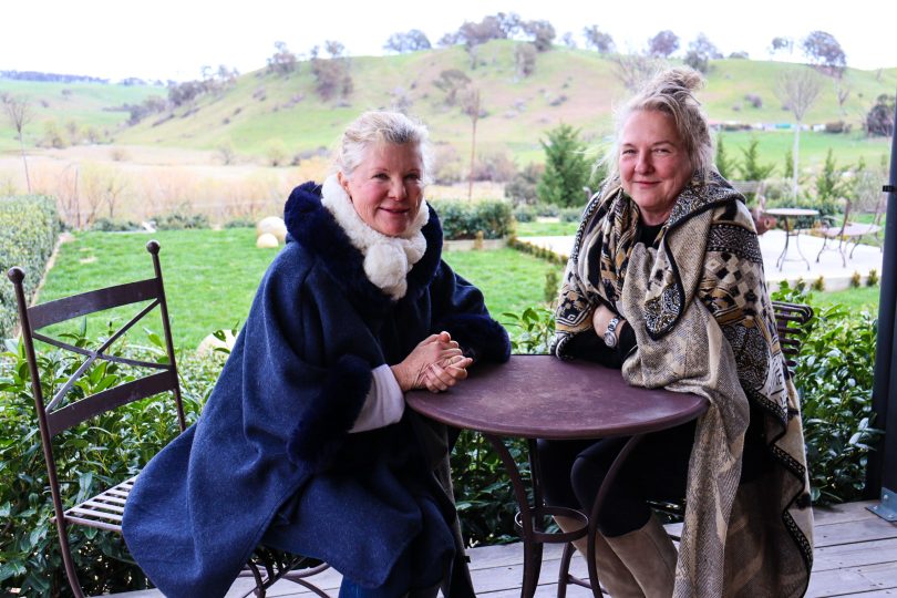 Libby Ratten (left) and Annette Hill (right) sitting at table on rural patio.