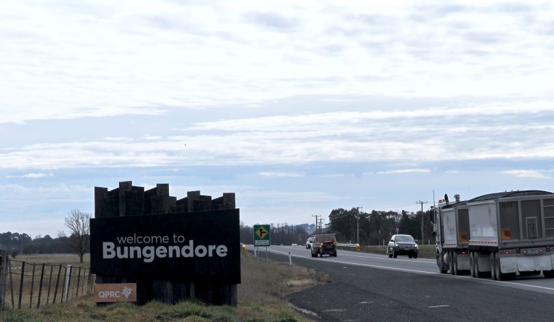 Cars and a truck on the road into Bungendore with 'welcome to Bungendore' sign