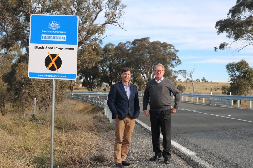 Federal Member for Hume Angus Taylor (left) and Goulburn Mulwaree Council Mayor Bob Kirk (right) standing beside Middle Arm Road. 