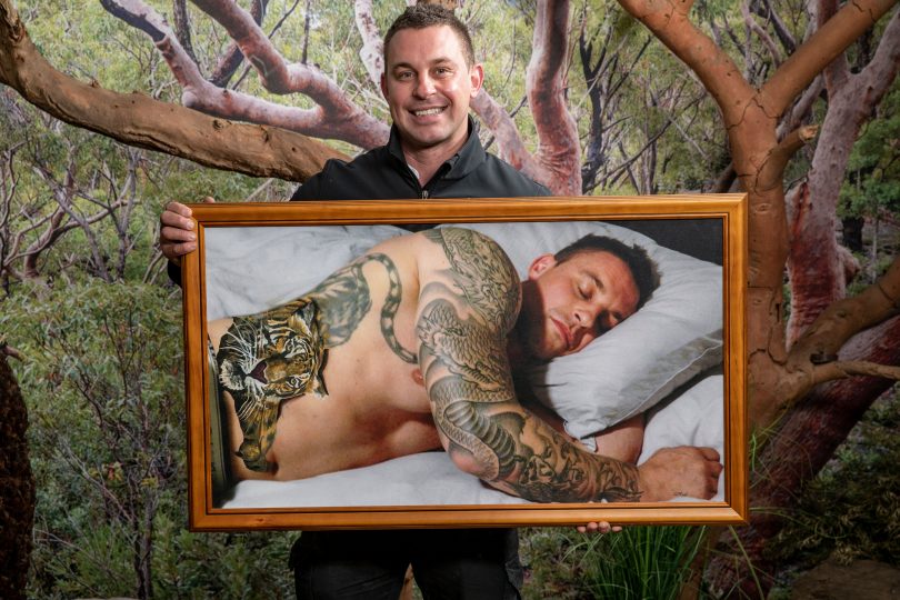 Chad Staples from Mogo Wildlife Park holding portrait painted by Lord DJ Stief.
