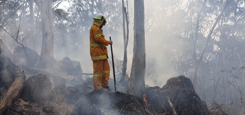 A NSW Rural Fire Service volunteer surrounded by bushfire smoke.