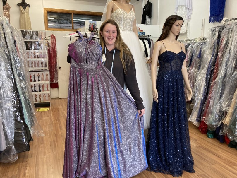 Ella Grant standing with her formal dress next to mannequin.