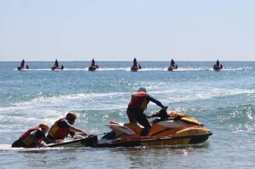 Surf lifesavers in training on jet ski.