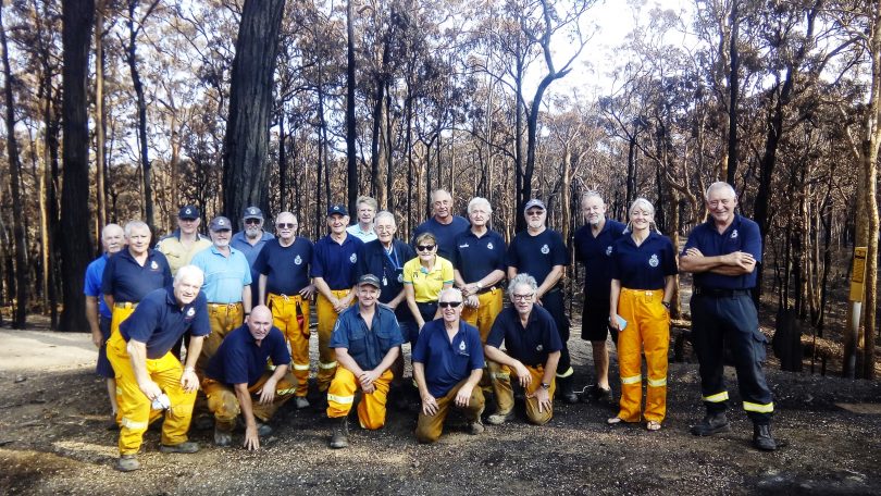 Members of the Malua Bay Rural Fire Brigade standing in burnt forest on New Year's Day 2020.