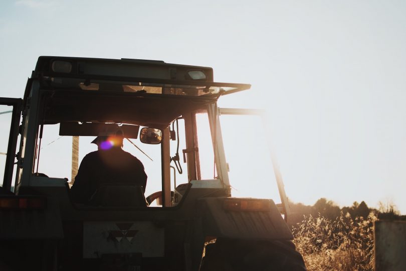 Farmer in tractor on farm.