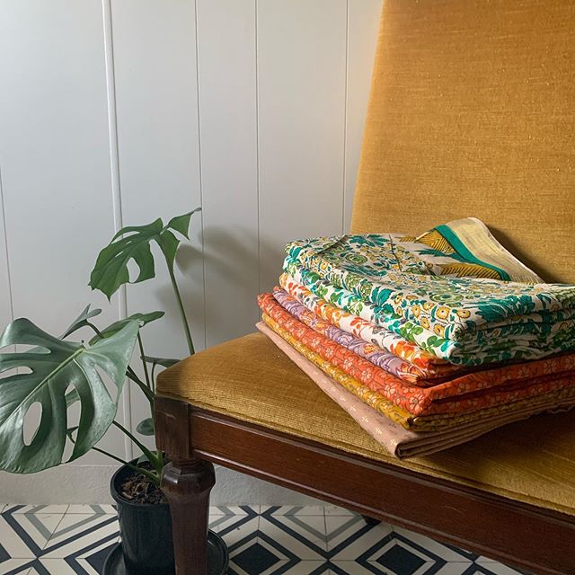 Pile of patterned fabrics on chair.