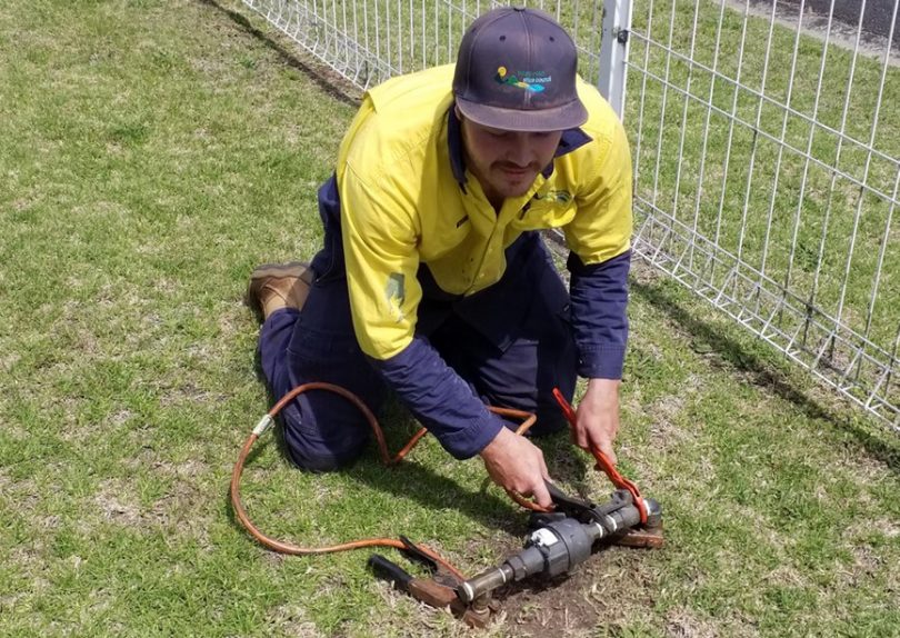 Bega Valley Shire Council worker replacing water meter.
