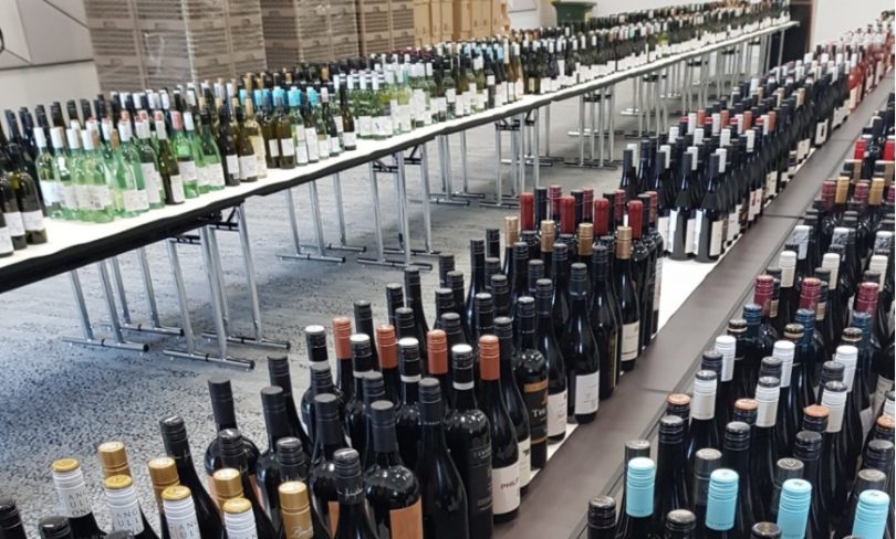 Hundreds of bottles of wine on tables.