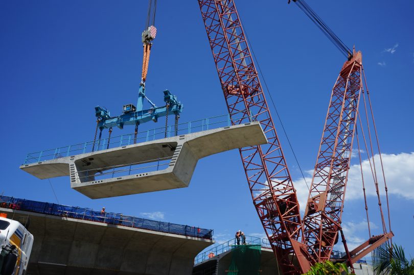 Concrete segment being placed into Batemans Bay Bridge by crane.