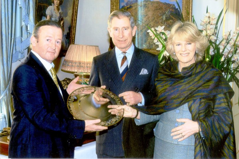 Peter Crisp, Prince Charles and the Duchess of Cornwall hold a Crisp Glass piece.