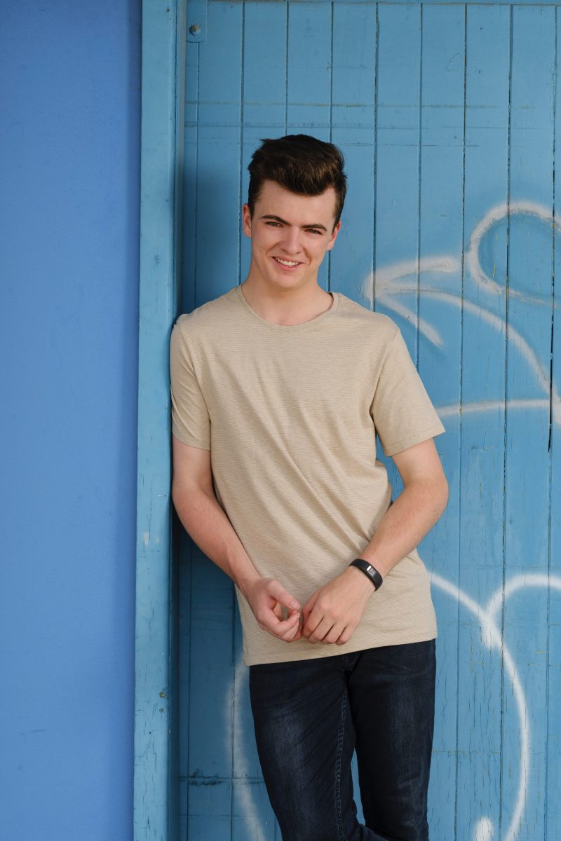 Harry Cleverdon posing in front of a blue door.