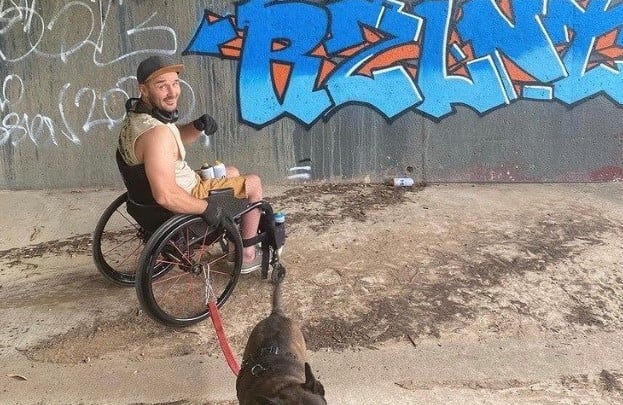 Jade Roche in wheelchair next to graffiti wall in Yass.