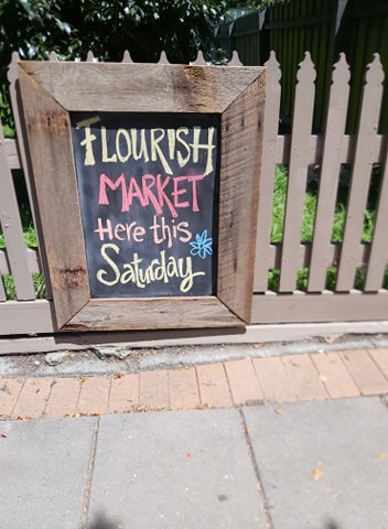 Chalkboard sign for Flourish market in Pambula.