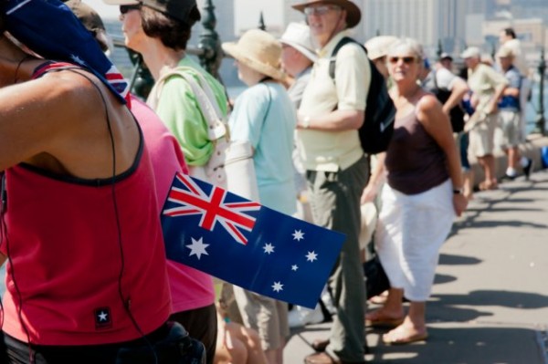 A woman holding Australian flag among a crowd.