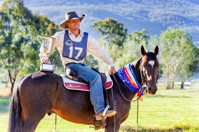 Kieran Davidson holding trophy on horseback.