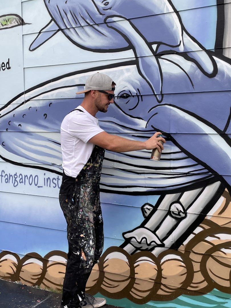Don Paull spray painting a mural in Batemans Bay.