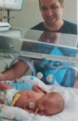 One of the triplets in the ICU with their dad.