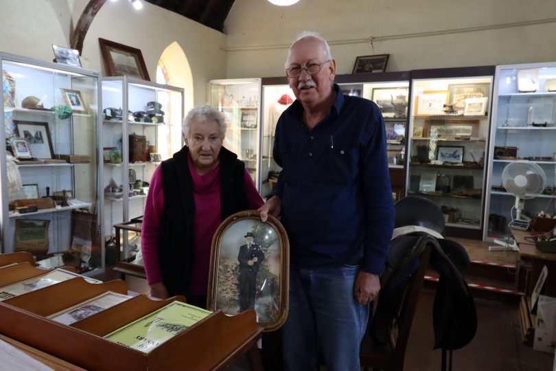 Mary and Michael Chalker hold a photo of Charles Walker inside Taralga Historical Society's Museum.