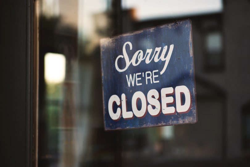 'Sorry we're closed' sign on shopfront.