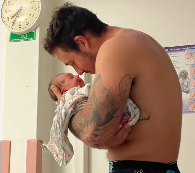 Grant Crapp cuddling his newborn baby, Charli, in hospital
