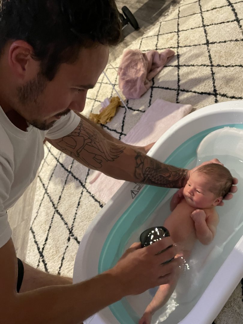 Grant Crapp bathing newborn Charli Crapp