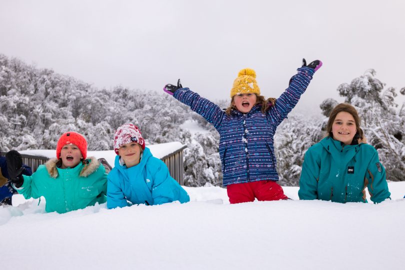 Four children playing in snow