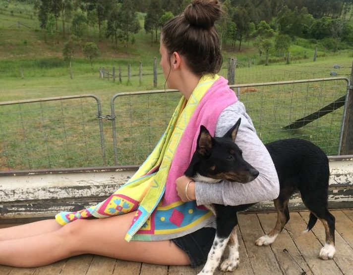 Hannah Sparks on a farm with dog