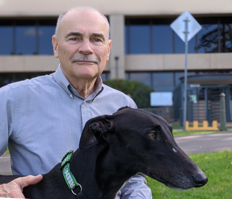 Dennis Anderson holding greyhound