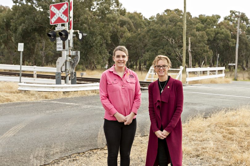 Maddie Bott and Steph Cooke standing at level-crossing