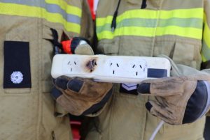 Fire officer holding burnt out powerboard